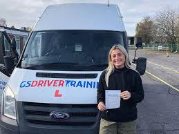 Woman holding a certificate in front of a GS Driver Training van, showcasing HGV training in Wiltshire.